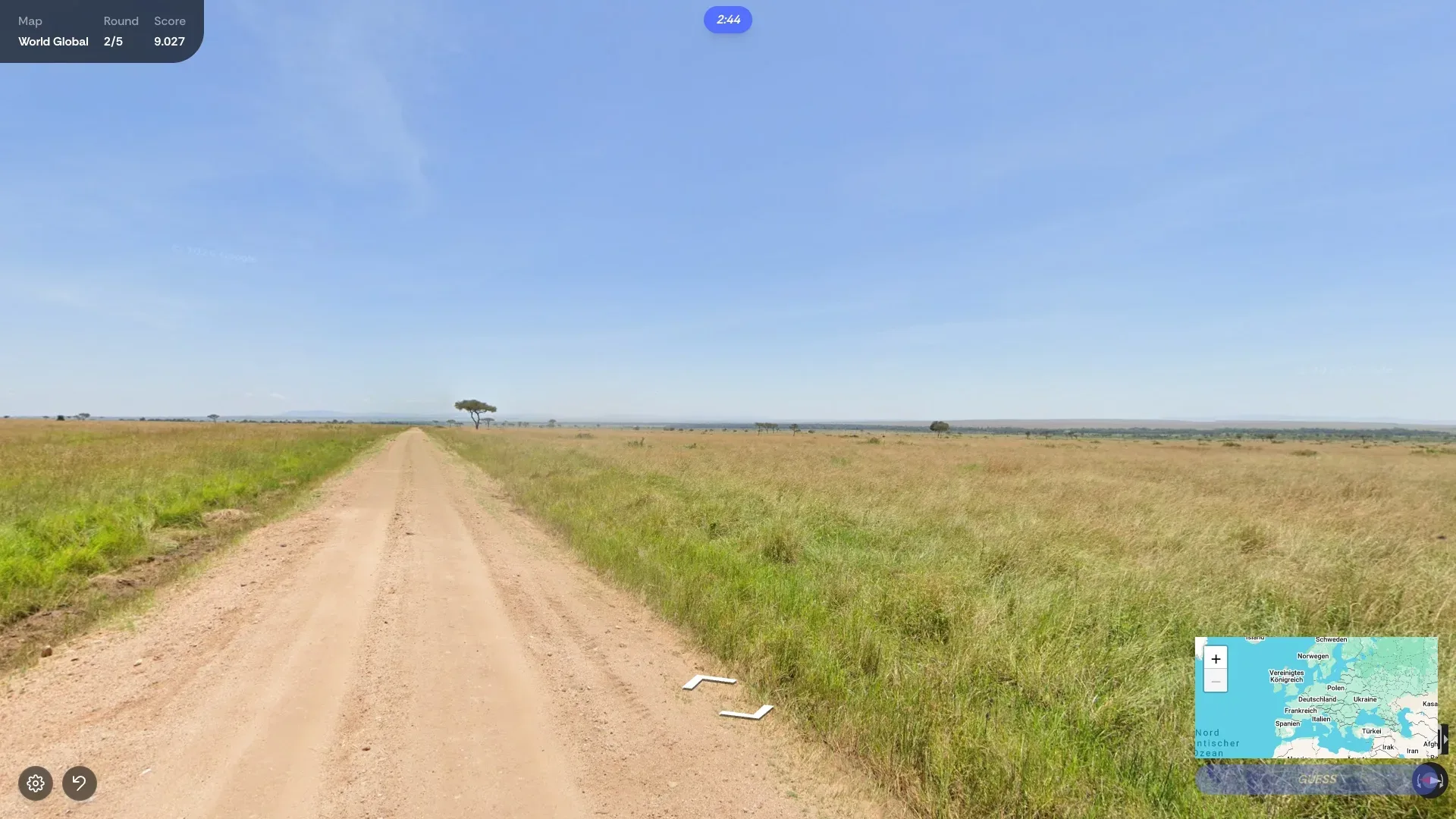 A dirt track across an open savannah, the world map ready in the corner for a guess