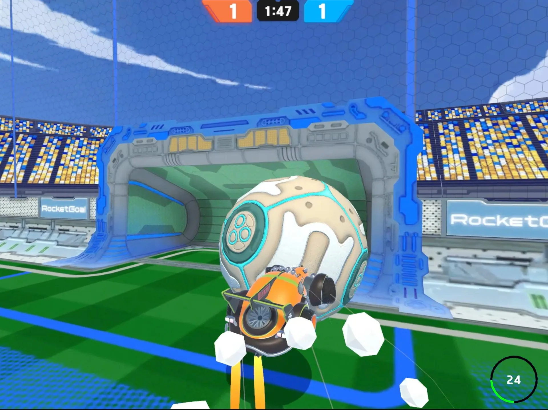 Orange car hitting the ball close to the goal with boost flames and white debris, score 1–1